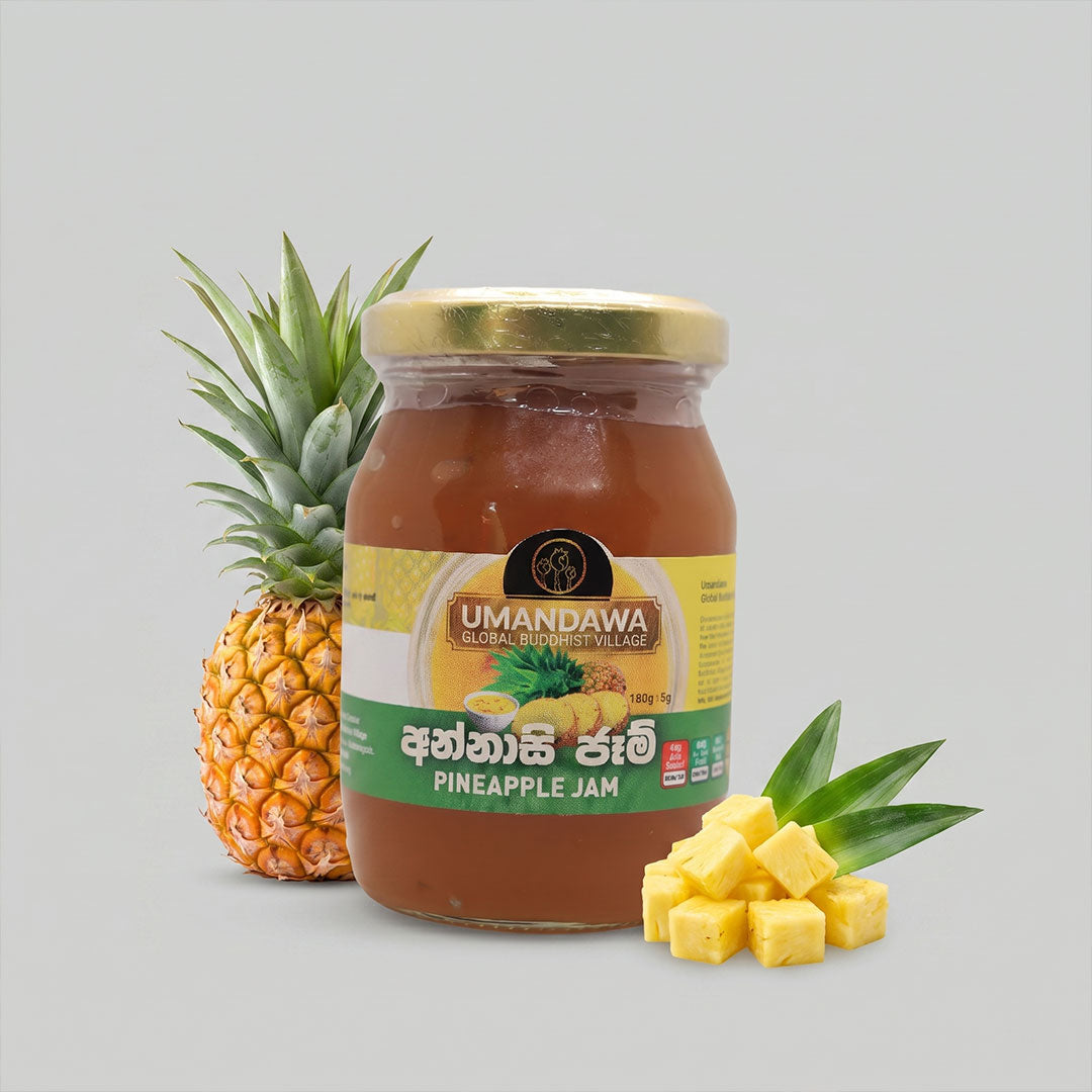 Jar of pineapple jam with fresh whole pineapple and pineapple cubes on light background