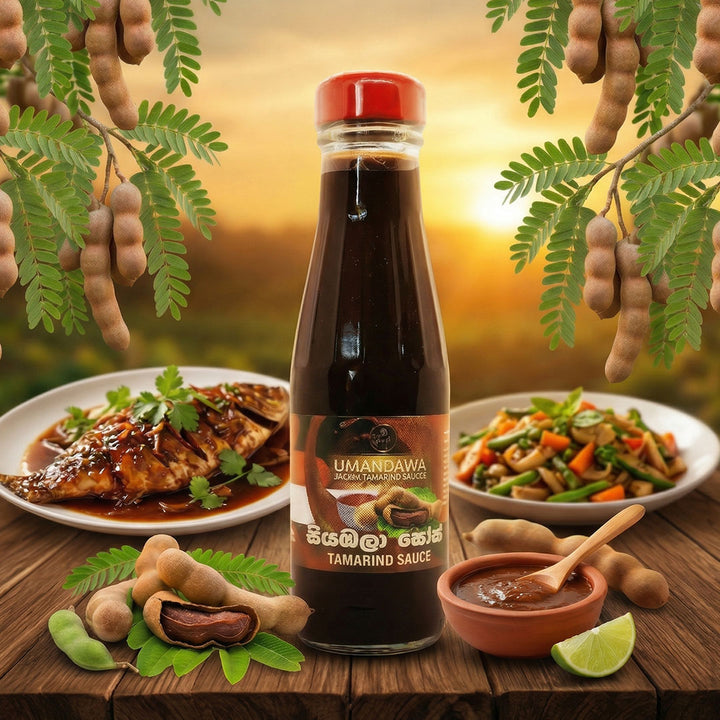 Bottle of tamarind sauce with tamarind pods, cooked fish, vegetables, and sauce on a rustic table